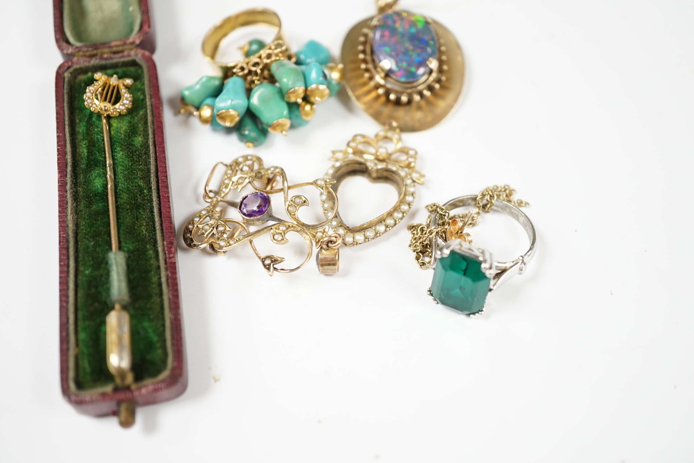 A group of jewellery including a yellow metal and seed pearl set stick pin, with lyre terminal and a 9ct and gem set pendant. Condition - poor to fair